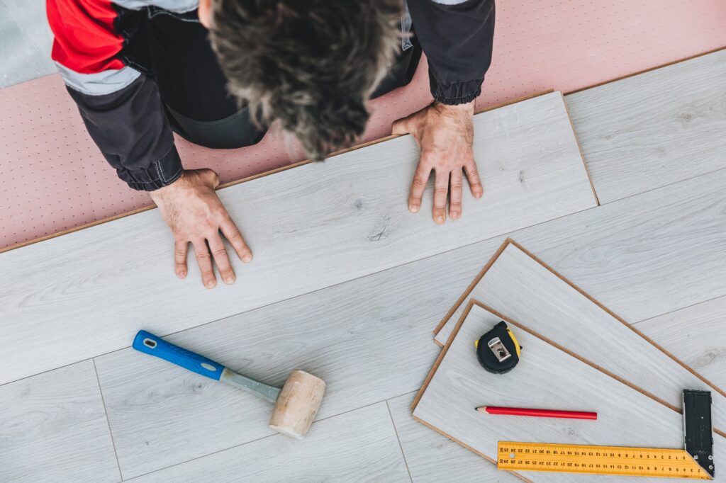 Man installing new laminated wooden floor